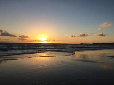 a sunset on a beach with the ocean at VillaConil in Conil de la Frontera