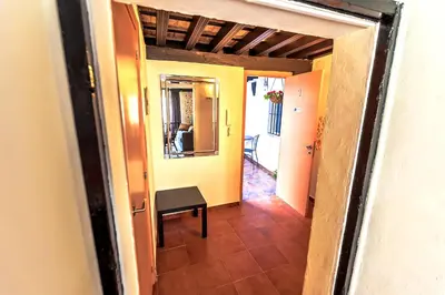 a hallway leading to a room with a table and a mirror at Milagros Central Apartments in El Puerto de Santa María