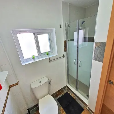a bathroom with a toilet and a glass shower at Milagros Central Apartments in El Puerto de Santa María