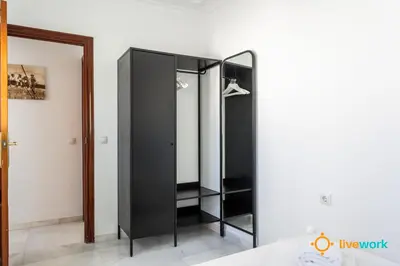 a black wardrobe in a room with a mirror at Torre Argantonio by LiveWork in Cádiz