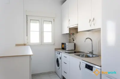 a white kitchen with a sink and a microwave at Torre Argantonio by LiveWork in Cádiz