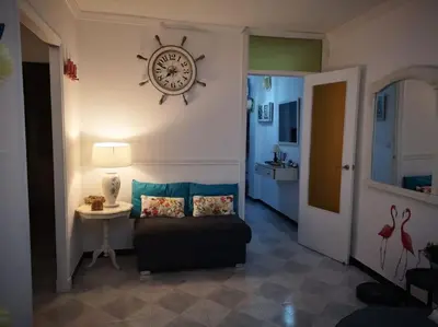 a living room with a couch and a clock on the wall at Mi pisito La Maña in San Fernando