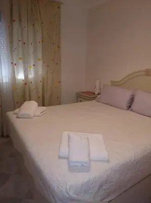 a bedroom with a bed with two towels on it at Mi pisito La Maña in San Fernando