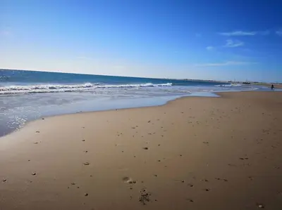 a beach with footprints in the sand and the ocean at Mi pisito La Maña in San Fernando