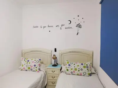 a bedroom with two beds with a moon and stars on the wall at Mi pisito La Maña in San Fernando