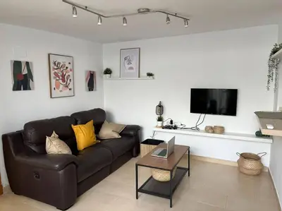 a living room with a leather couch and a table at La Candela by Gades Gestión in Cádiz