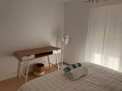 a bedroom with a bed and a desk and a window at La Candela by Gades Gestión in Cádiz