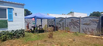 a fence with a mural on it next to a house at Vacaciones en Novo Sancti Petri in Chiclana de la Frontera