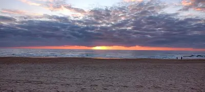 a sunset on a beach with the ocean at Vacaciones en Novo Sancti Petri in Chiclana de la Frontera