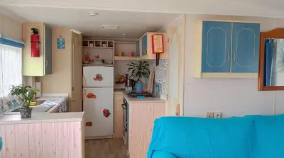 a small kitchen with blue cabinets and a refrigerator at Vacaciones en Novo Sancti Petri in Chiclana de la Frontera