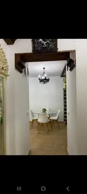 a dining room with a table and chairs and a chandelier at Apartamento Donna Elvira in Caserío Bogás