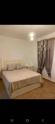 a bedroom with a bed in a room with curtains at Apartamento Donna Elvira in Caserío Bogás