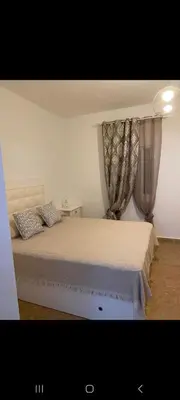 a kitchen with a table and a white chair and a table at Apartamento Donna Elvira in Caserío Bogás