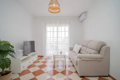a living room with a couch and a tv at SibsSanlucar Azahar Centrico Vistas Terraza Coqueto in Sanlúcar de Barrameda