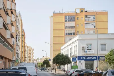 a busy city street with cars parked in front of buildings at SibsSanlucar Azahar Centrico Vistas Terraza Coqueto in Sanlúcar de Barrameda