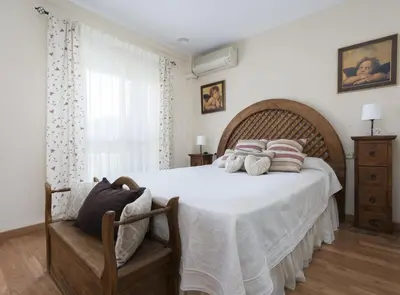 a bedroom with a large bed and a window at Chalet Pareado & Piscina in El Puerto de Santa María