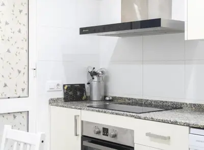 a kitchen with white cabinets and a stove top oven at Chalet Pareado & Piscina in El Puerto de Santa María