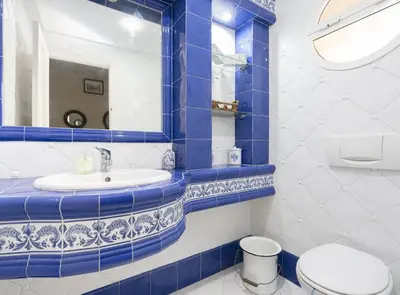 a blue and white bathroom with a toilet and a sink at Chalet Pareado & Piscina in El Puerto de Santa María