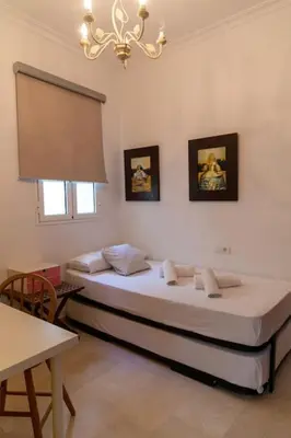 a bedroom with two beds and a chandelier at Alameda by Gades Gestión in Cádiz