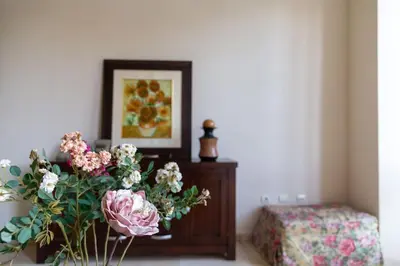 a vase of flowers on a table next to a bed at Alameda by Gades Gestión in Cádiz