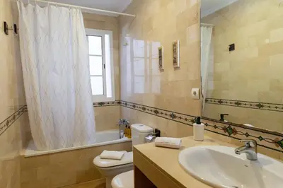 a bathroom with a sink and a toilet and a mirror at Alameda by Gades Gestión in Cádiz