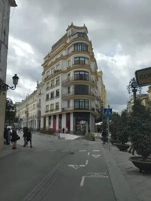 a large building on a street with people walking in front of it at ÁTICO Edificio RIANAL in Jerez de la Frontera