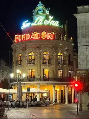 a large building with a sign on it at night at ÁTICO Edificio RIANAL in Jerez de la Frontera