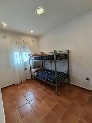 a room with two bunk beds and a tile floor at Villa TRANQUILA in Chiclana de la Frontera