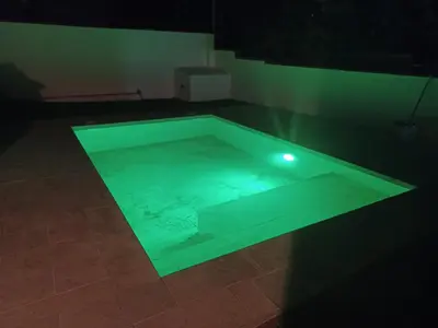 a swimming pool with a green light in a room at Villa TRANQUILA in Chiclana de la Frontera