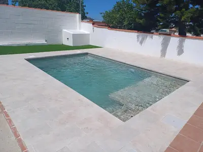 a swimming pool in front of a white wall at Villa TRANQUILA in Chiclana de la Frontera