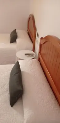 a room with two beds and a table with a pillow at Hotel Arcos-Coruña in Arcos de la Frontera