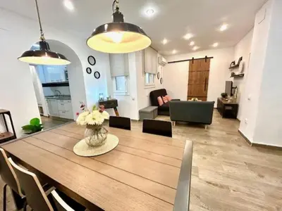 a dining room and living room with a table and chairs at GATU Castillo , 