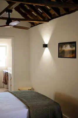 a bedroom with a bed with a light on the wall at El Sur Medina-Sidonia in Medina Sidonia