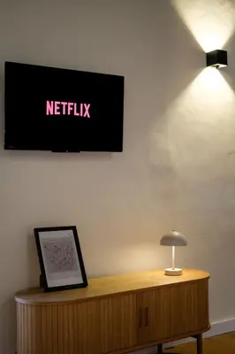 a television on a wall above a table with a lamp at El Sur Medina-Sidonia in Medina Sidonia