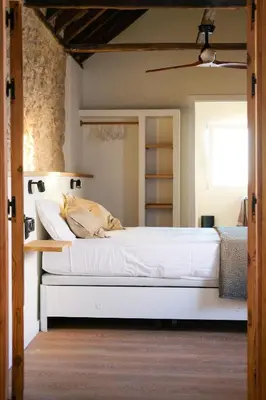a bedroom with a large bed with white sheets at El Sur Medina-Sidonia in Medina Sidonia