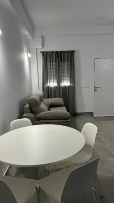 a white table and chairs in a room with a couch at Lacana in Chiclana de la Frontera