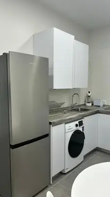 a kitchen with a white refrigerator and a sink at Lacana in Chiclana de la Frontera