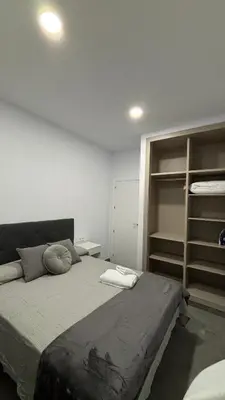 a bedroom with a large bed and some shelves at Lacana in Chiclana de la Frontera