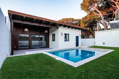 a house with a swimming pool in the yard at villa woody playa in Chiclana de la Frontera