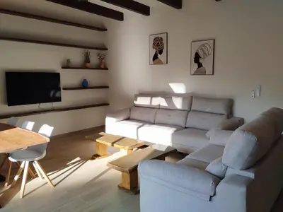 a living room with a couch and a table at villa woody playa in Chiclana de la Frontera