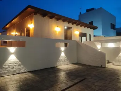 a white building with lights on the side of it at villa woody playa in Chiclana de la Frontera