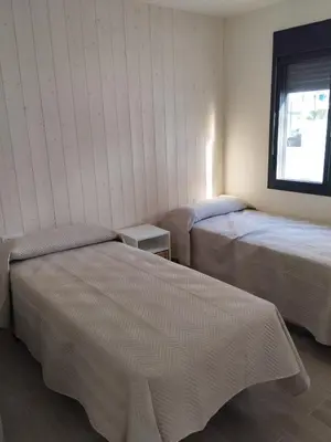 a bedroom with two beds and a window at villa woody playa in Chiclana de la Frontera