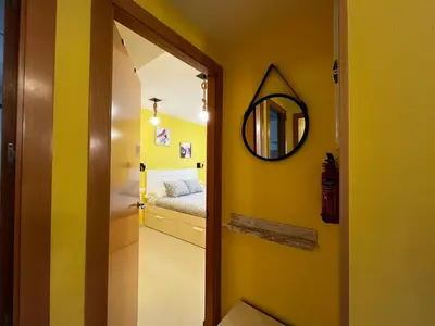 a yellow room with a mirror and a bed at Penthouse San Felix Grupo AC Gestion in Cádiz