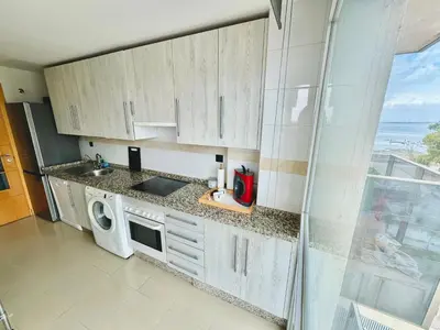 a kitchen with white cabinets and a washing machine at Bahía Azul Suites, Piscina & Pádel in San Fernando