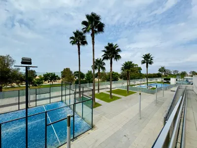 a view of a swimming pool with palm trees at Bahía Azul Suites, Piscina & Pádel in San Fernando