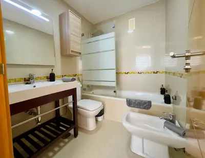 a bathroom with a toilet and a sink and a tub at Bahía Azul Suites, Piscina & Pádel in San Fernando