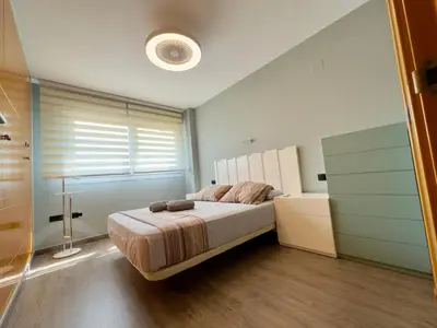 a bedroom with a large bed and a window at Bahía Azul Suites, Piscina & Pádel in San Fernando