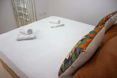 a white bed with two towels on top of it at Centro Villamarta Moderno in Jerez de la Frontera
