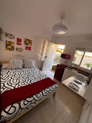 a bedroom with a large bed and a desk at Aires de Sanlúcar in Sanlúcar de Barrameda