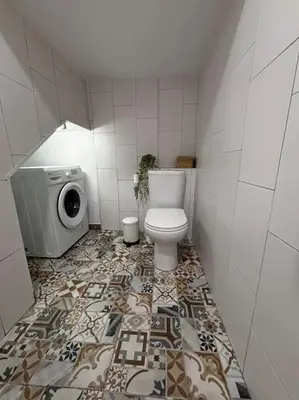 a bathroom with a toilet and a washing machine at Aires de Sanlúcar in Sanlúcar de Barrameda